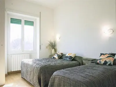 a bedroom with two beds and a window at B&B Dea Tiburtina in Rome