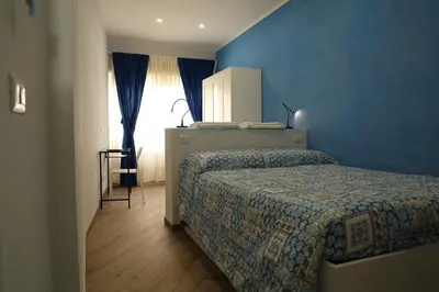 a bedroom with a bed and a blue wall at Affittacamere Arte nei Colori in Rome