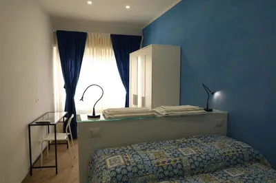 a bedroom with a bed and a desk and a window at Affittacamere Arte nei Colori in Rome