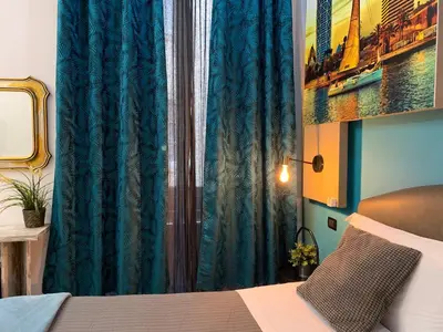 a bedroom with a bed and a blue curtain at CityLife Rome in Rome