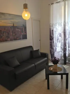 a living room with a black couch and a table at CityLife Rome in Rome