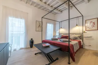 a bedroom with a canopy bed and a table at GuestHost - Piazza Venezia&Colosseum Loft in Rome
