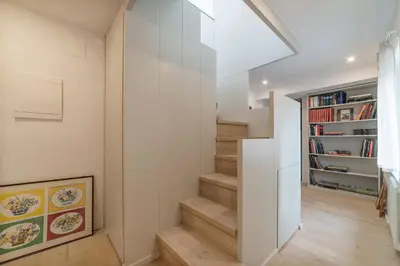 a staircase in a home with white walls and wooden floors at GuestHost - Piazza Venezia&Colosseum Loft in Rome