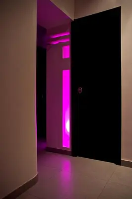 a purple door with a pink light in a room at Roma Naif Rooms in Rome