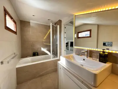 a bathroom with a sink and a bath tub and a mirror at Art Lover's Loft in Rome