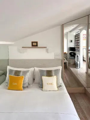 a bedroom with a white bed with two yellow pillows at Art Lover's Loft in Rome