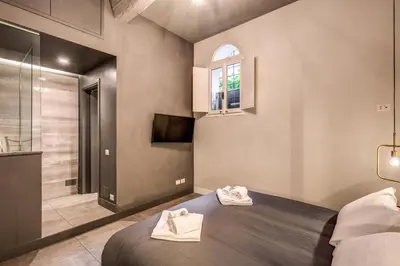 a bedroom with a bed and a bathroom with a shower at 11 Via di Sant'Eligio in Rome