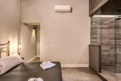 a bedroom with a bed and a glass shower at 11 Via di Sant'Eligio in Rome
