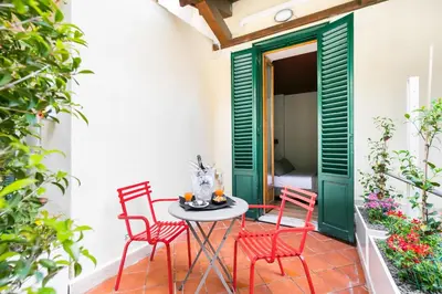 a bedroom with a bed with red pillows and chairs at Hotel La Rovere in Rome