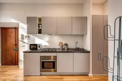 a kitchen with white cabinets and a stove top oven at Sant'Eligio 2BDR in Rome