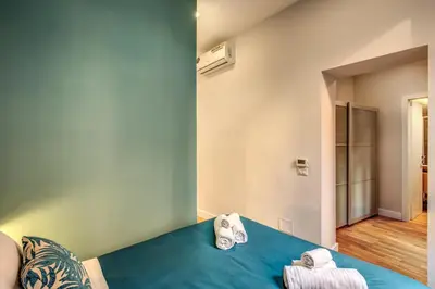 a room with a blue bed with towels on it at Sant'Eligio 2BDR in Rome