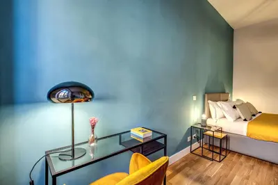 a bedroom with a bed and a glass table with a chair at Sant'Eligio 2BDR in Rome