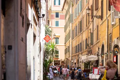 a group of people walking down a street with buildings at POP Art B&B in Rome