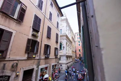 a group of people walking down a narrow street at POP Art B&B in Rome