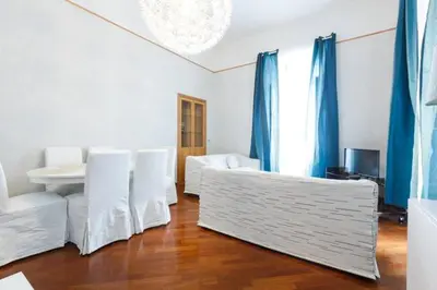 a living room with white furniture and blue curtains at Casa Vacanze Risorgimento in Rome