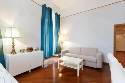 a living room with a white couch and blue curtains at Casa Vacanze Risorgimento in Rome