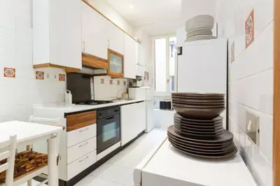a white kitchen with a stack of plates on a counter at Casa Vacanze Risorgimento in Rome