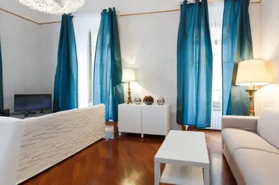 a living room with blue curtains and a couch at Casa Vacanze Risorgimento in Rome