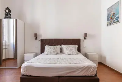 a bedroom with a large bed with white sheets and pillows at Appartamento Via Genova in Rome