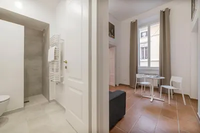a bathroom with a toilet and a table with chairs at Appartamento Via Genova in Rome
