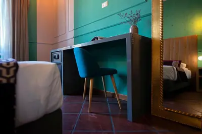 a blue chair sitting under a mirror next to a tv at Town House Campo De Fiori in Rome