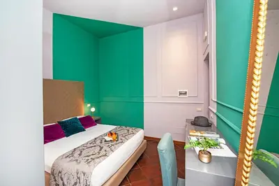 a bedroom with green walls and a bed and a table at Town House Campo De Fiori in Rome