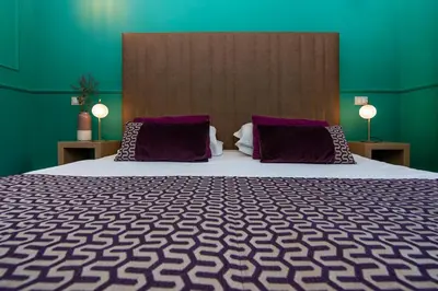 a bedroom with a large bed with purple pillows at Town House Campo De Fiori in Rome