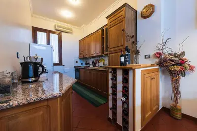 a kitchen with wooden cabinets and a bunch of wine bottles at Toberto Apartment in Rome