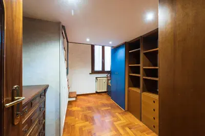 a room with a closet with a blue door and wooden floors at Toberto Apartment in Rome