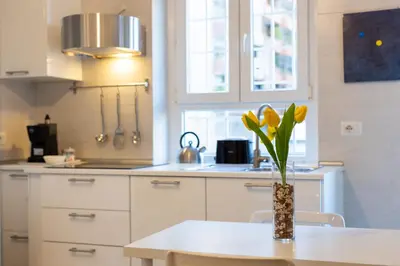 a kitchen with a vase with yellow flowers on a table at Ottoboni Apartment, 4 persone, balcone, Wi-Fi, Stazione Tiburtina in Rome