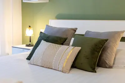 a bed with a bunch of pillows on it at Ottoboni Apartment, 4 persone, balcone, Wi-Fi, Stazione Tiburtina in Rome