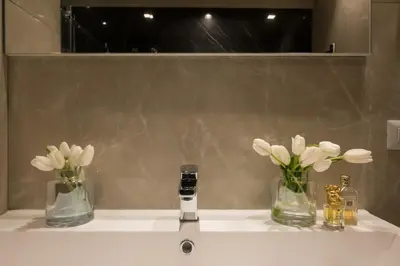 a bathroom sink with three vases with flowers on it at Marvellous apt near Vatican in Rome