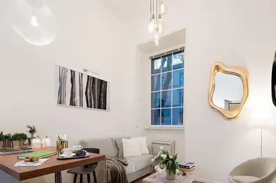 a living room with a table and a mirror at Marvellous apt near Vatican in Rome