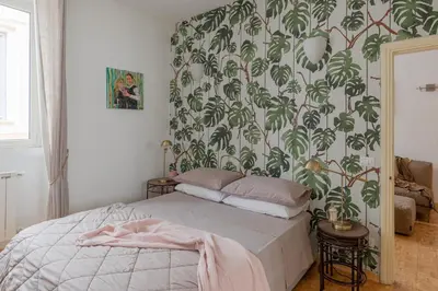 a bedroom with a bed with a green and white wallpaper at Giglio quiet apartment at Campo dei Fiori in Rome