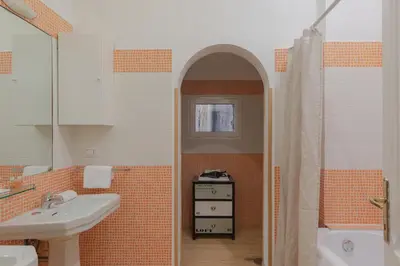 an orange and white bathroom with a sink and a shower at Giglio quiet apartment at Campo dei Fiori in Rome