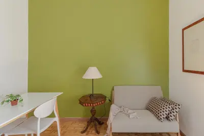 a room with a chair and a table and a lamp at Giglio quiet apartment at Campo dei Fiori in Rome