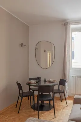a dining room with a table and chairs and a mirror at Giglio quiet apartment at Campo dei Fiori in Rome
