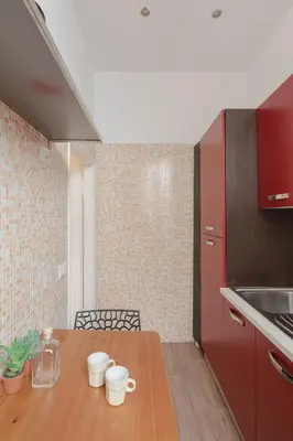 a kitchen with a wooden table with mugs on it at Giglio quiet apartment at Campo dei Fiori in Rome