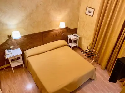 a small bedroom with a bed and two lamps at Sweet Dream Roma Termini in Rome