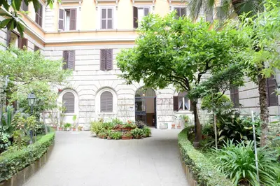 a courtyard of a building with trees and plants at Sweet Dream Roma Termini in Rome