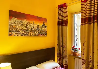 a yellow bedroom with a painting on the wall at Sweet Dream Roma Termini in Rome