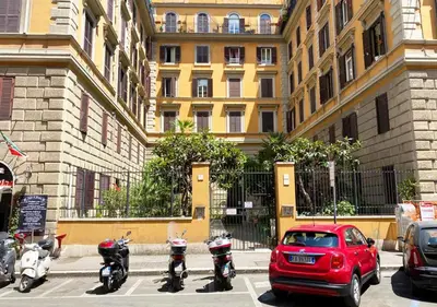 a red car parked in a parking lot next to a building at Sweet Dream Roma Termini in Rome