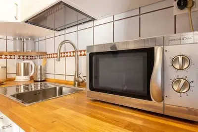 a kitchen with a stainless steel microwave on a counter at Romantic & Comfy Apartment Monteverde in Rome