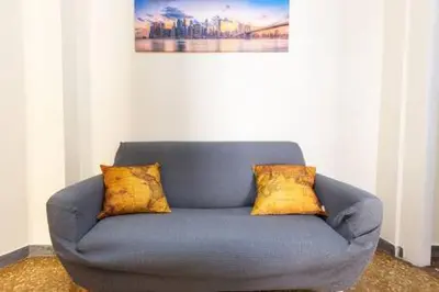 a blue couch with four yellow pillows on it at Romantic & Comfy Apartment Monteverde in Rome