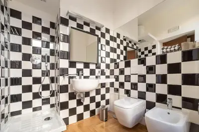 a bathroom with a black and white checkered wall at Lombardia40 Luxury Suites in Rome