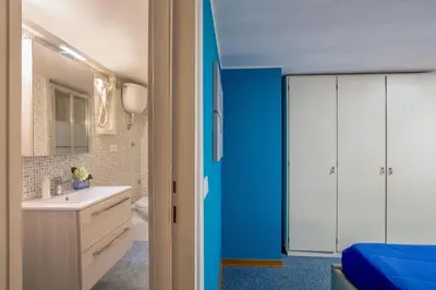 a bathroom with a white sink and a blue wall at Navona Blue Apartment in Rome
