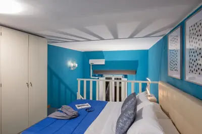 a blue bedroom with a bed with a blue wall at Navona Blue Apartment in Rome