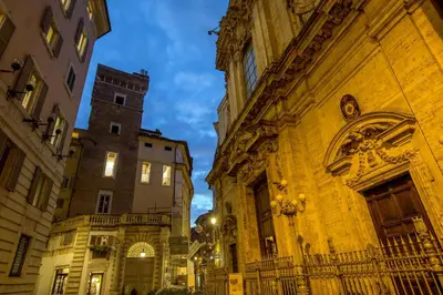 an alley between two buildings in a city at night at Navona White Apartment in Rome