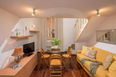 a living room with a yellow couch and a table at Navona White Apartment in Rome