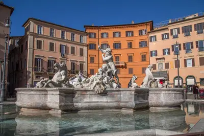 a fountain in the middle of a city with buildings at Navona White Apartment in Rome